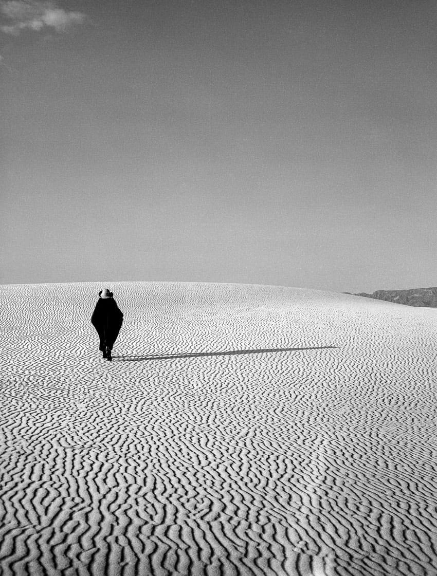 Black and white medium format film image of a man at the sand dunes in New Mexico - White Sands by Madison Lloyd on Shoot It With Film