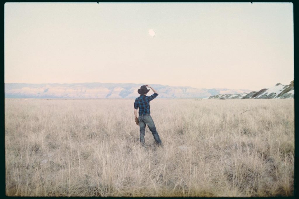 35mm film image of a man looking out into the desert - A Desert Road Trip Photo Essay by Valerian Ponsero on Shoot It With Film